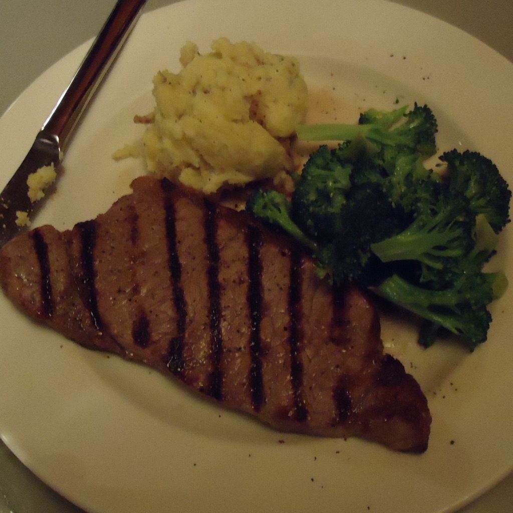 Before: the steak plate cut off at the edges, with a knife in frame