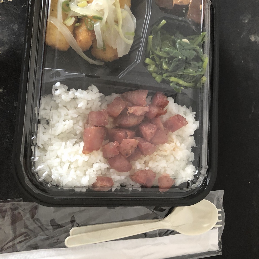 Before: the rice lunch box at an angle on a dark table, with a napkin and spoon